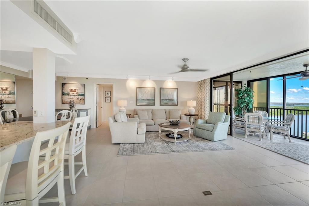 Living room featuring a ceiling fan, floor to ceiling windows, light tile patterned floors, and crown molding