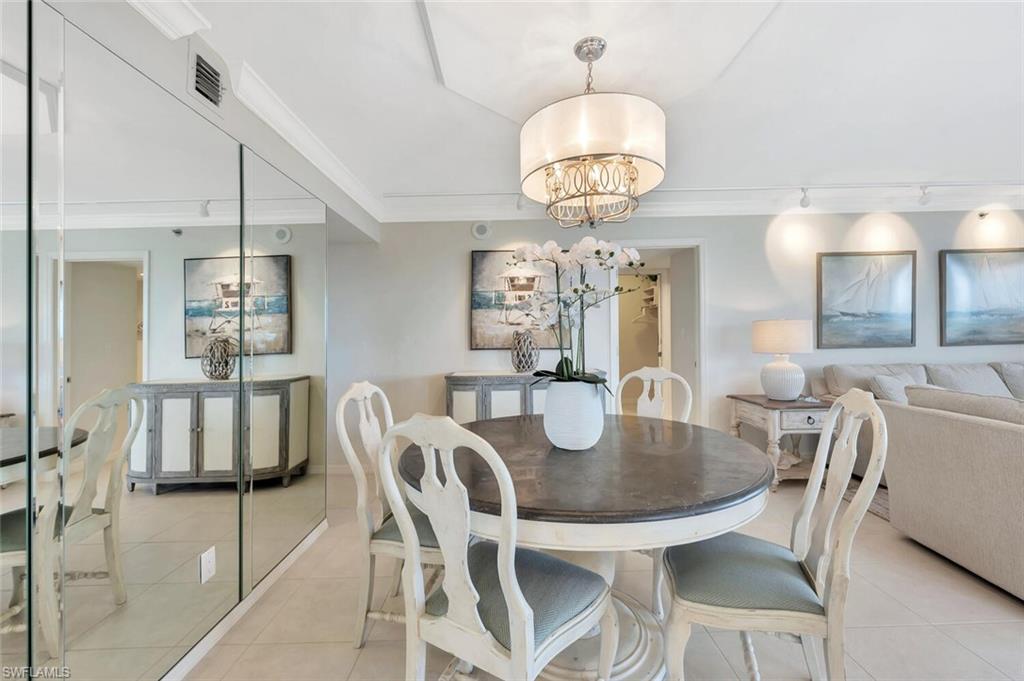 Dining area with a chandelier, light tile patterned floors, and crown molding