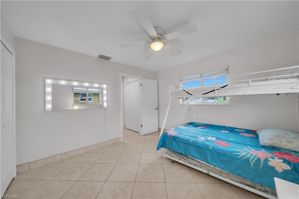 Tiled bedroom featuring ceiling fan