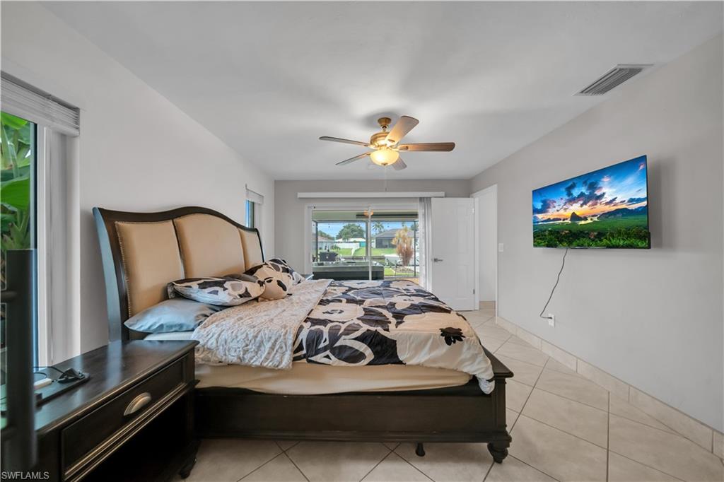 Bedroom featuring access to outside, light tile patterned flooring, and a ceiling fan