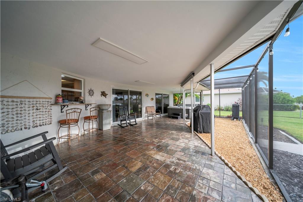 View of patio with a sunroom, a lanai, and grilling area