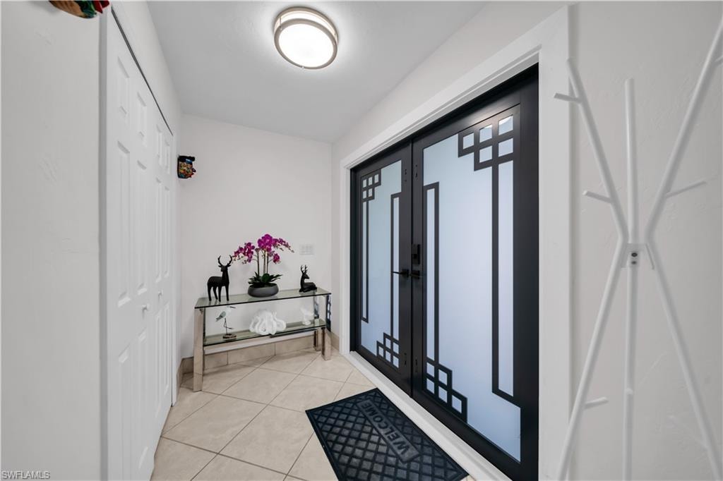Foyer entrance with light tile patterned flooring and french doors