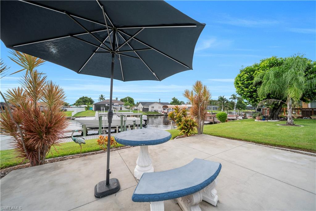 View of patio featuring a water view, a boat dock, a residential view, and boat lift