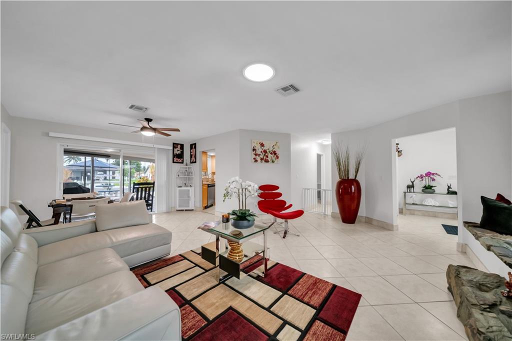 Living area featuring light tile patterned floors and a ceiling fan