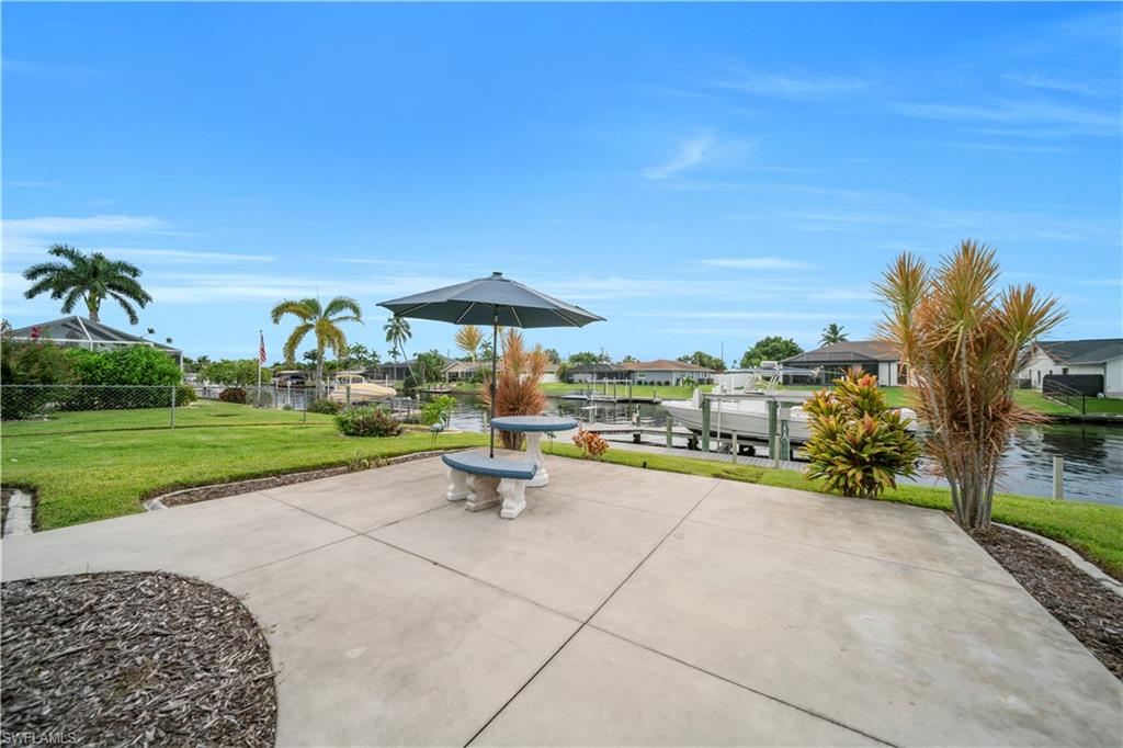 View of patio / terrace with boat lift, a boat dock, a water view, and a residential view