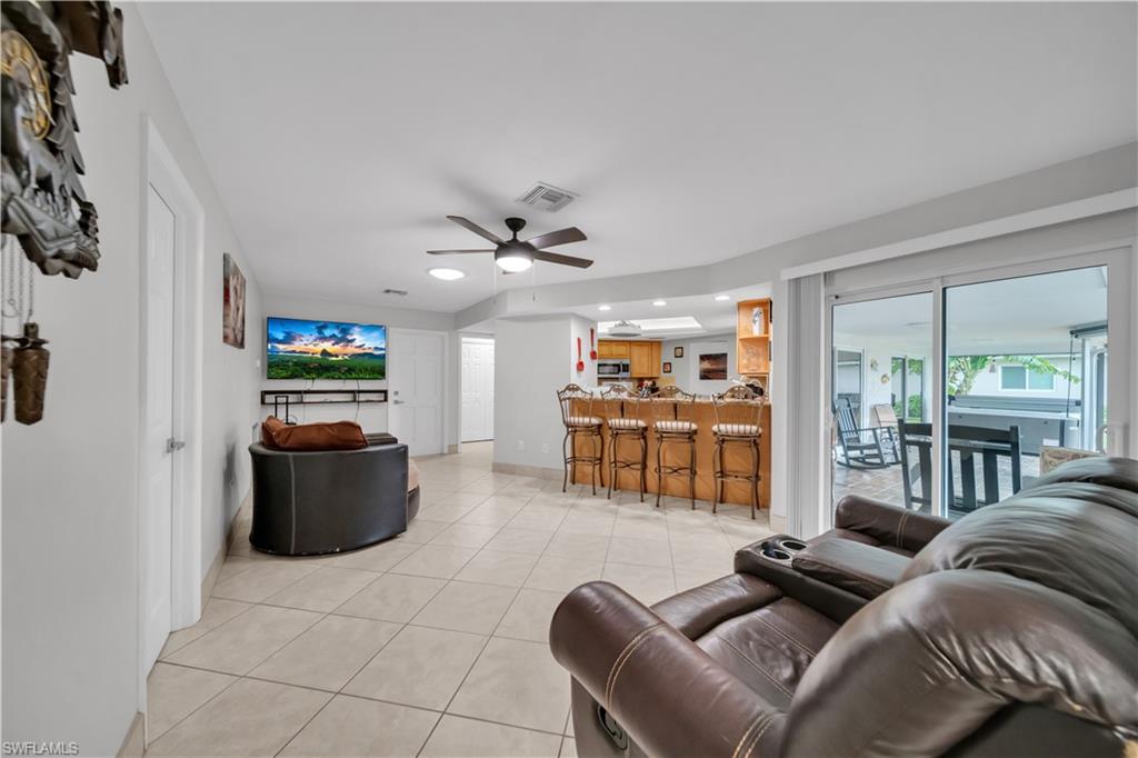 Living room with light tile patterned floors, a ceiling fan, and recessed lighting