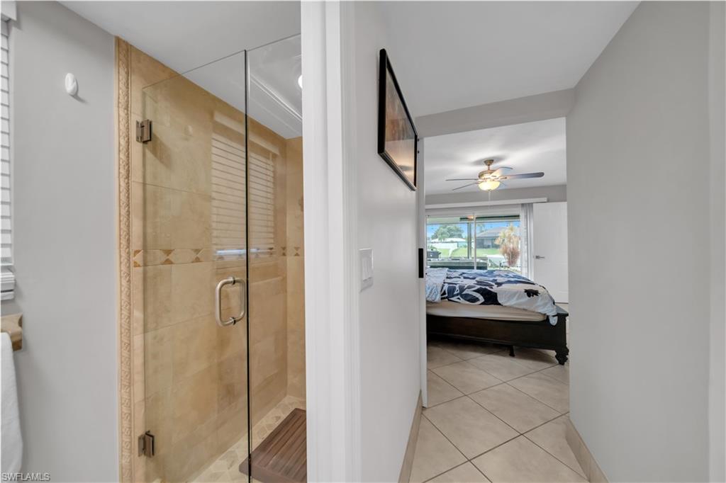 Ensuite bathroom featuring light tile patterned floors and a shower stall
