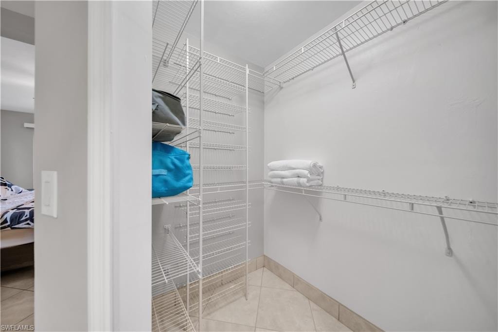 Walk in closet with light tile patterned floors