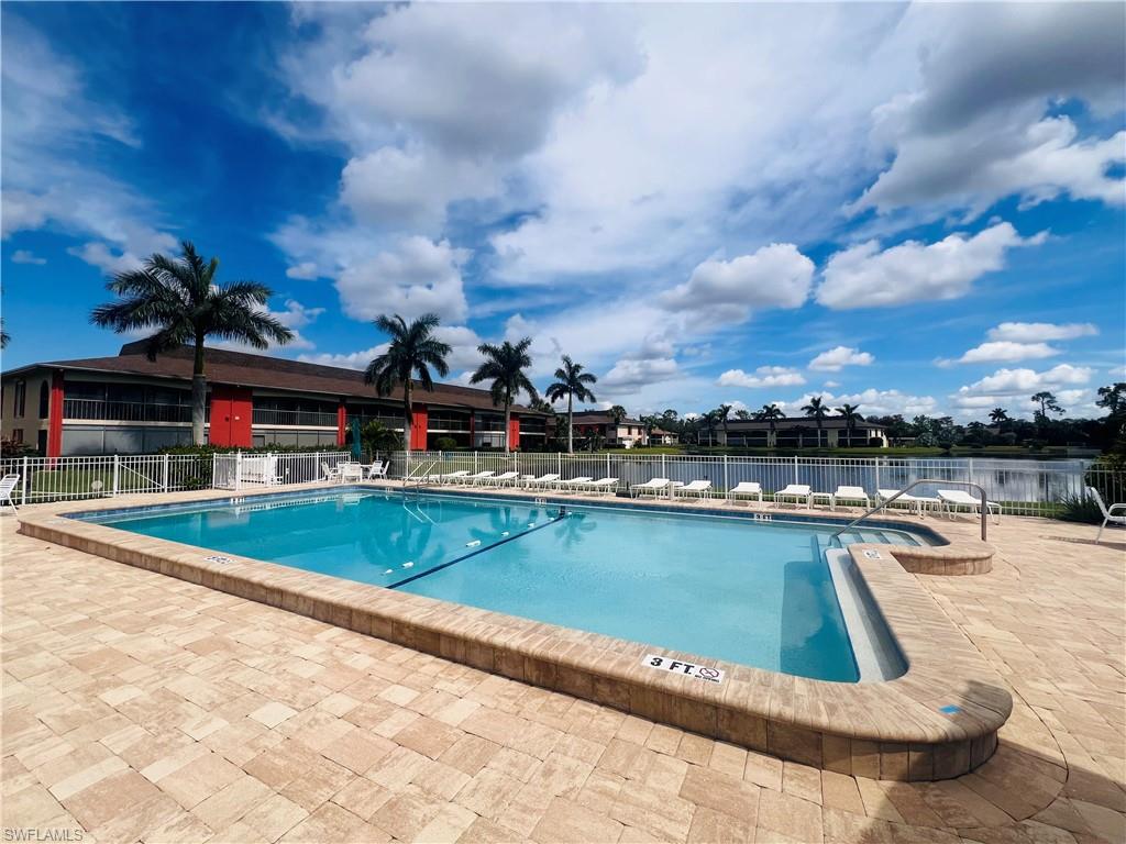 View of swimming pool with a water view and a patio