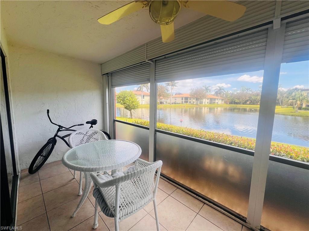 Screened-in lanai featuring a water view and ceiling fan