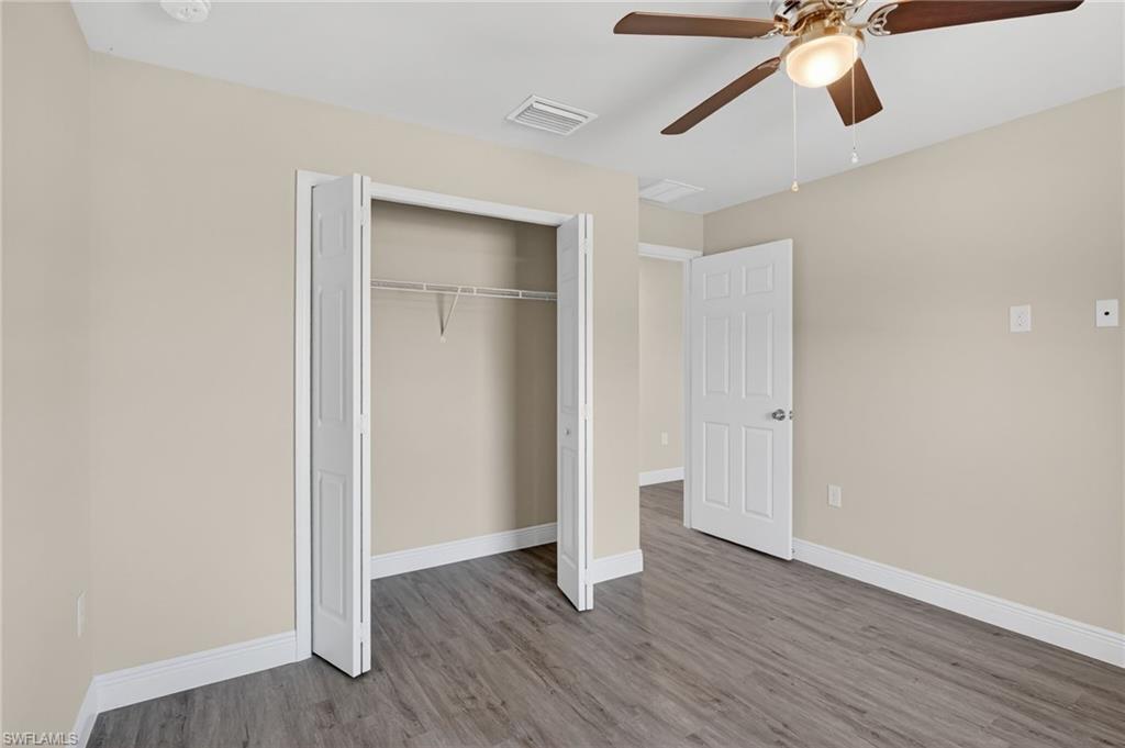 Unfurnished bedroom featuring a ceiling fan, a closet, and wood finished floors
