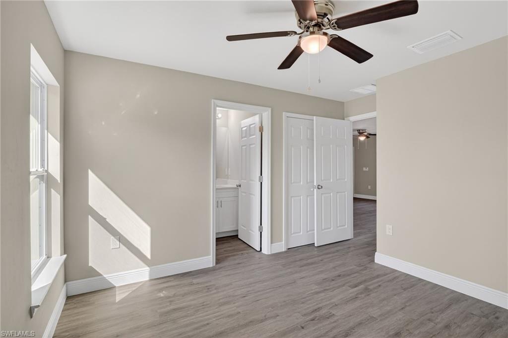 Unfurnished bedroom with light wood-style floors, a ceiling fan, and ensuite bathroom