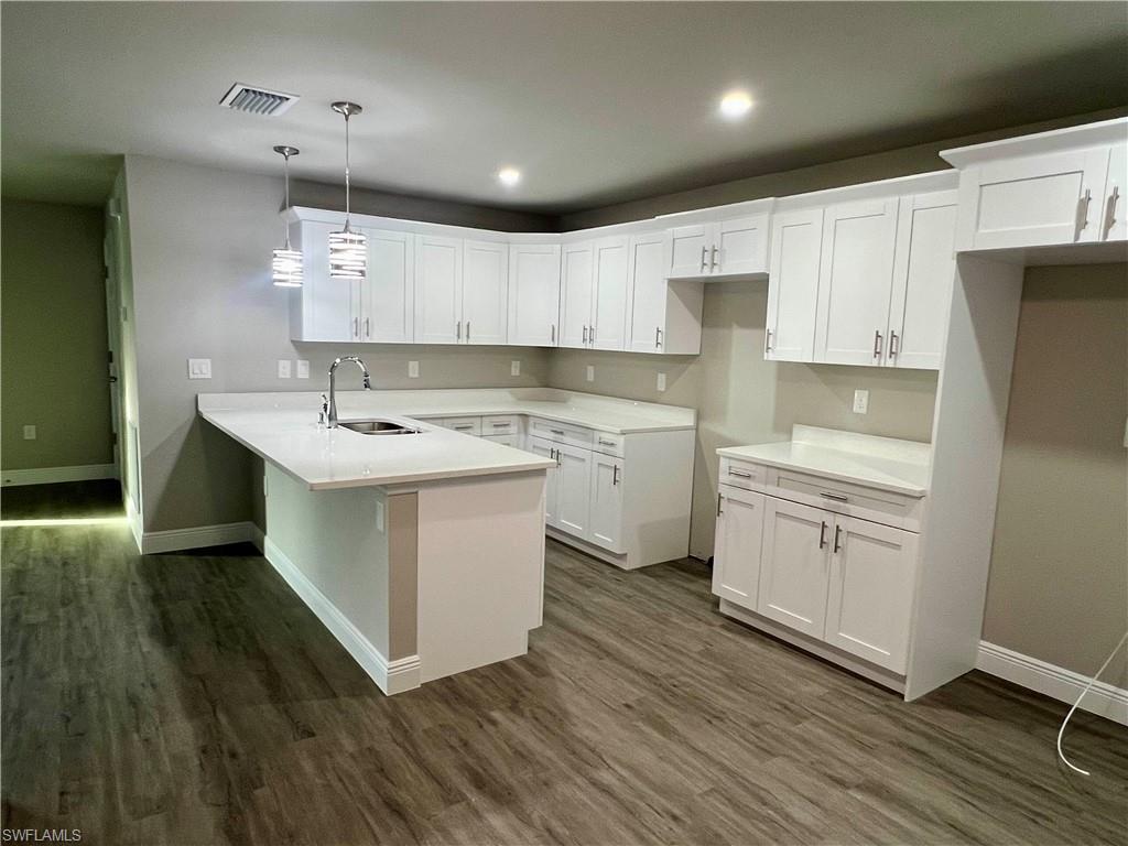 Unfurnished living room featuring dark wood-style flooring, a ceiling fan, and recessed lighting