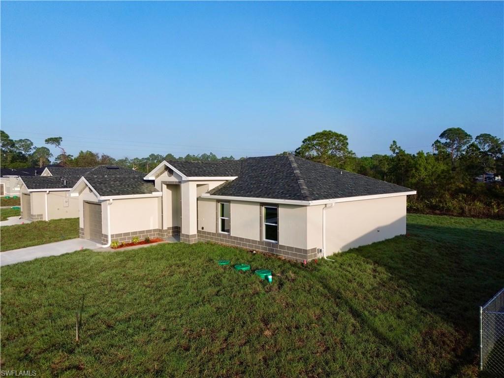 Ranch-style home with stucco siding, a front yard, driveway, and a garage