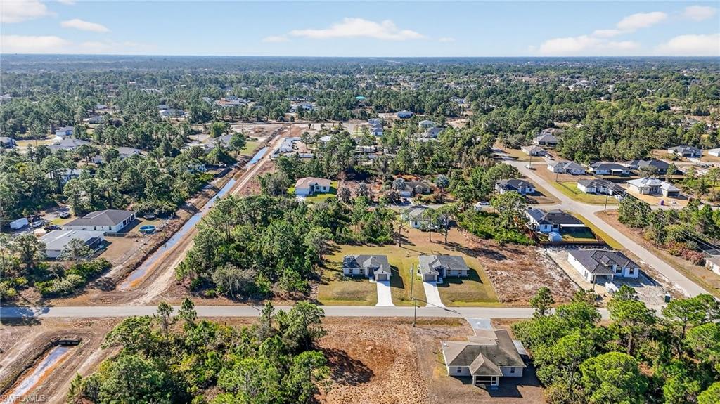 Aerial view of property and surrounding area with nearby suburban area