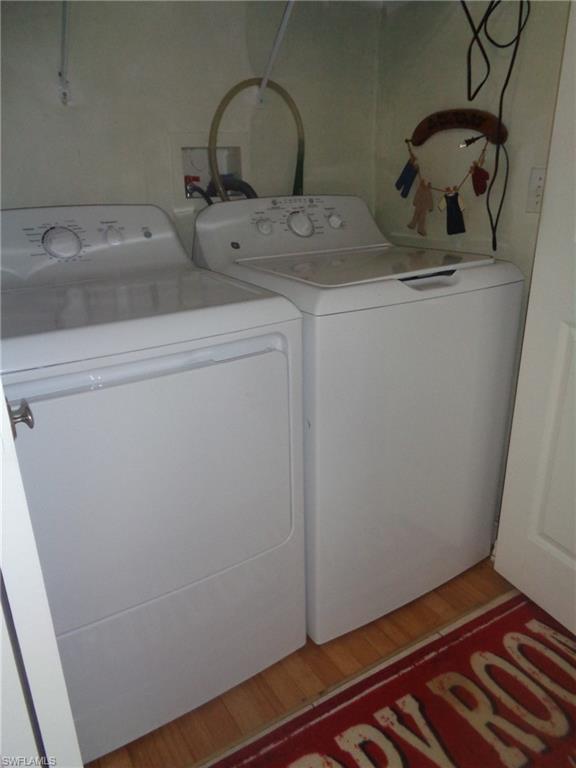 Laundry area with light wood-style flooring and washer and clothes dryer
