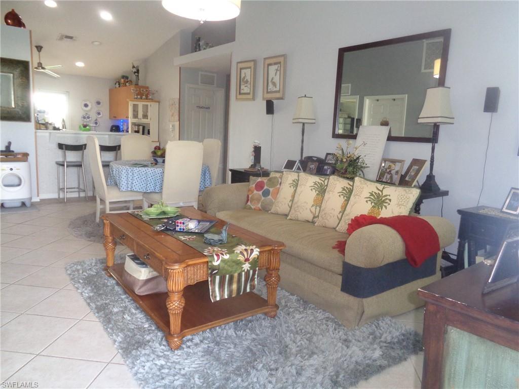 Living area featuring light tile patterned floors, washer / dryer, recessed lighting, and a ceiling fan