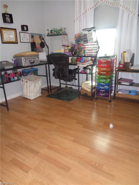 Bedroom turned into office featuring light wood-style flooring