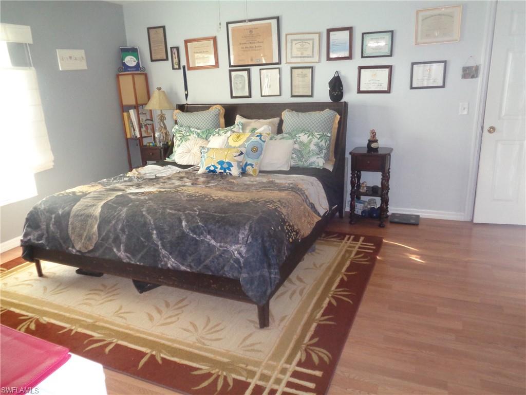 Bedroom with wood finished floors and baseboards