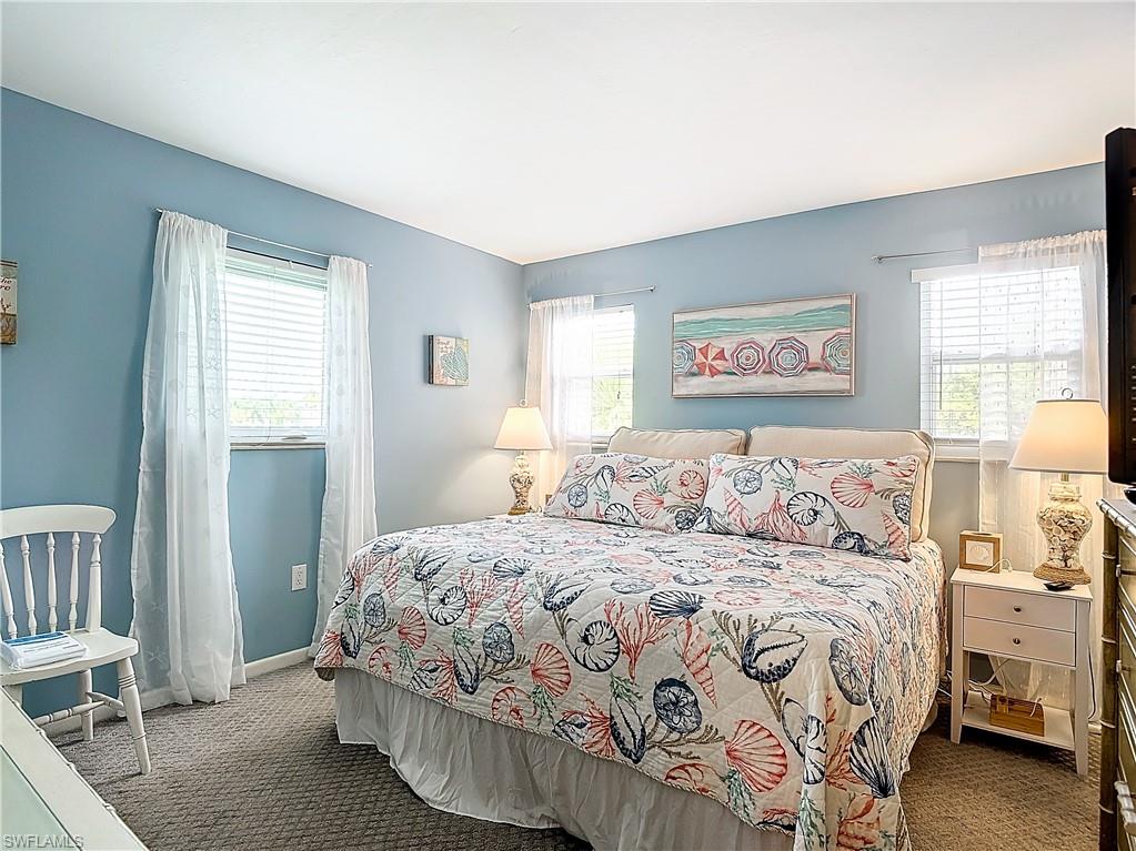 Bedroom with carpet and multiple windows