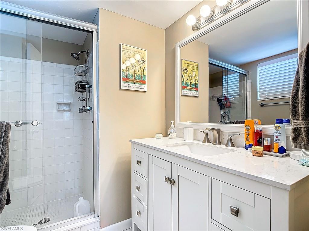 Bathroom featuring an enclosed shower and vanity