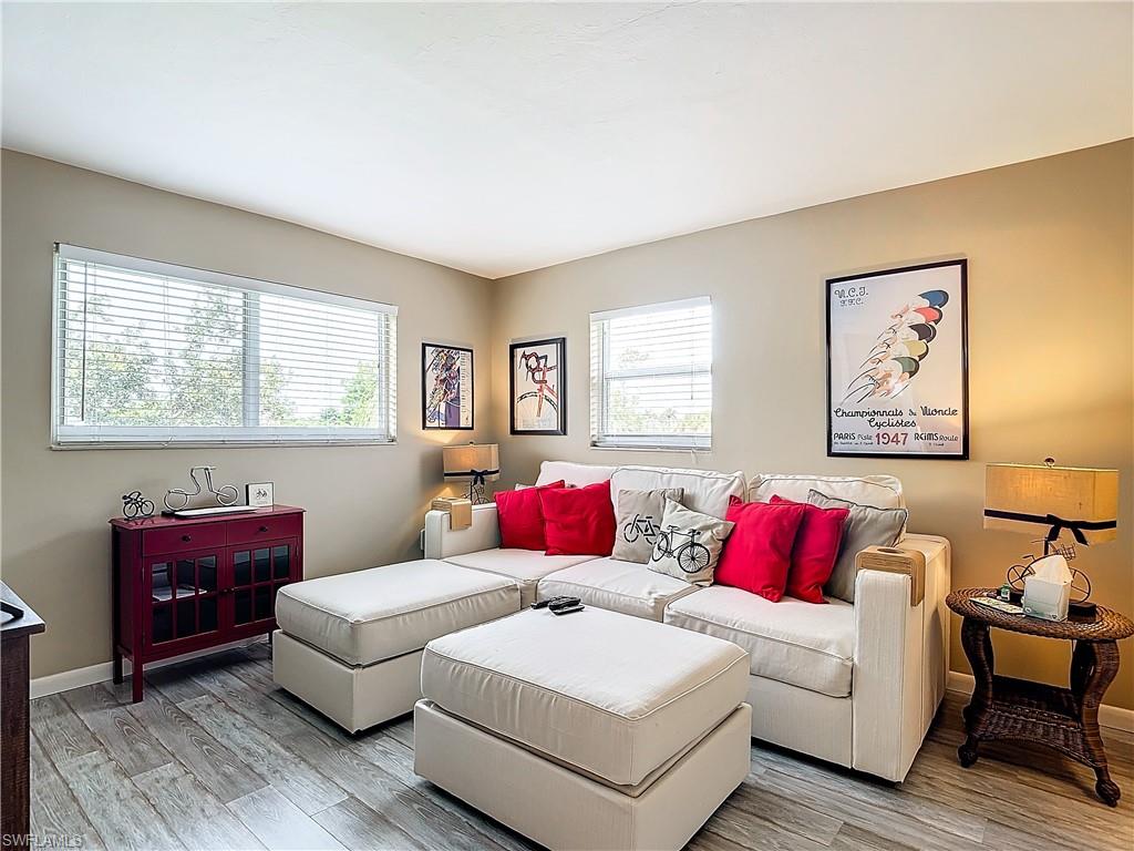 Living room with light wood-type flooring and a healthy amount of sunlight