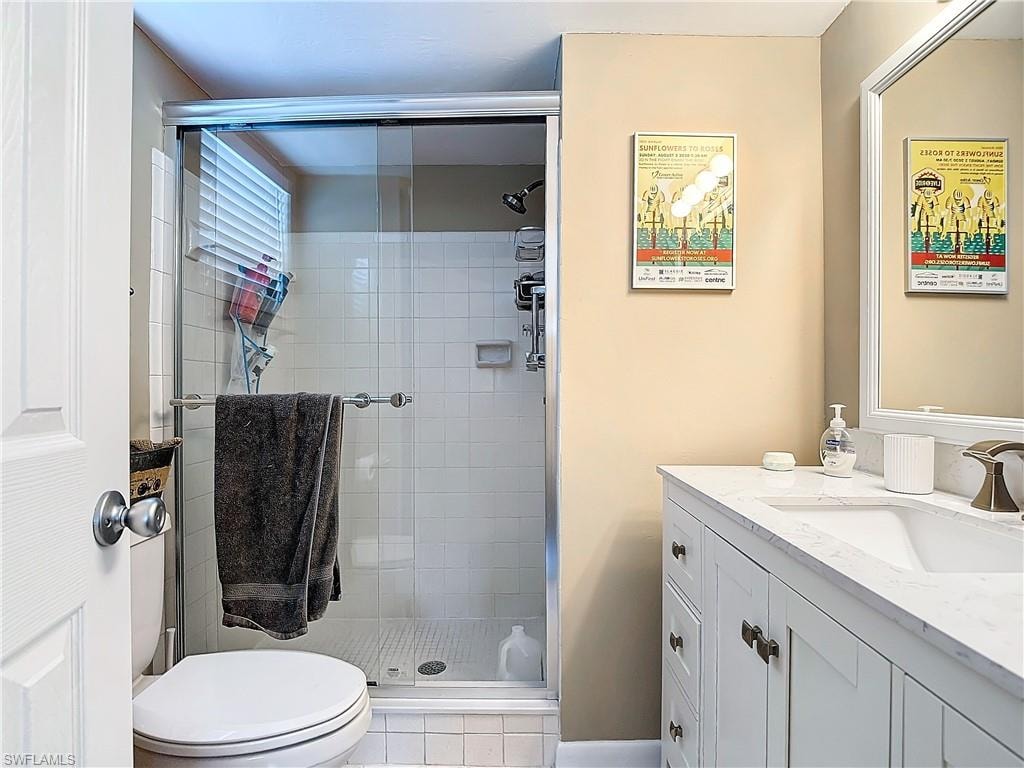 Bathroom with an enclosed shower, vanity, and toilet