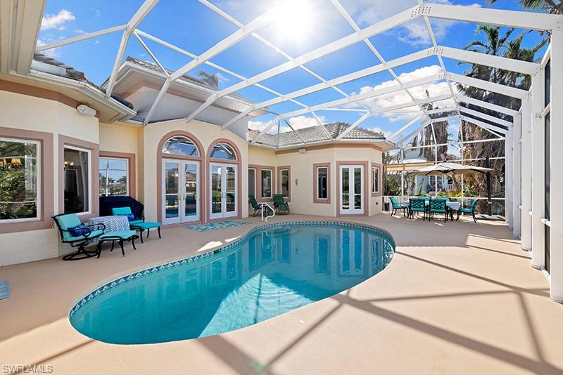 View of swimming pool with a lanai, a patio area, and french doors
