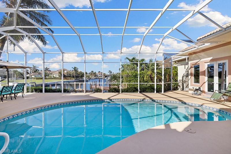 View of pool with glass enclosure and a patio area