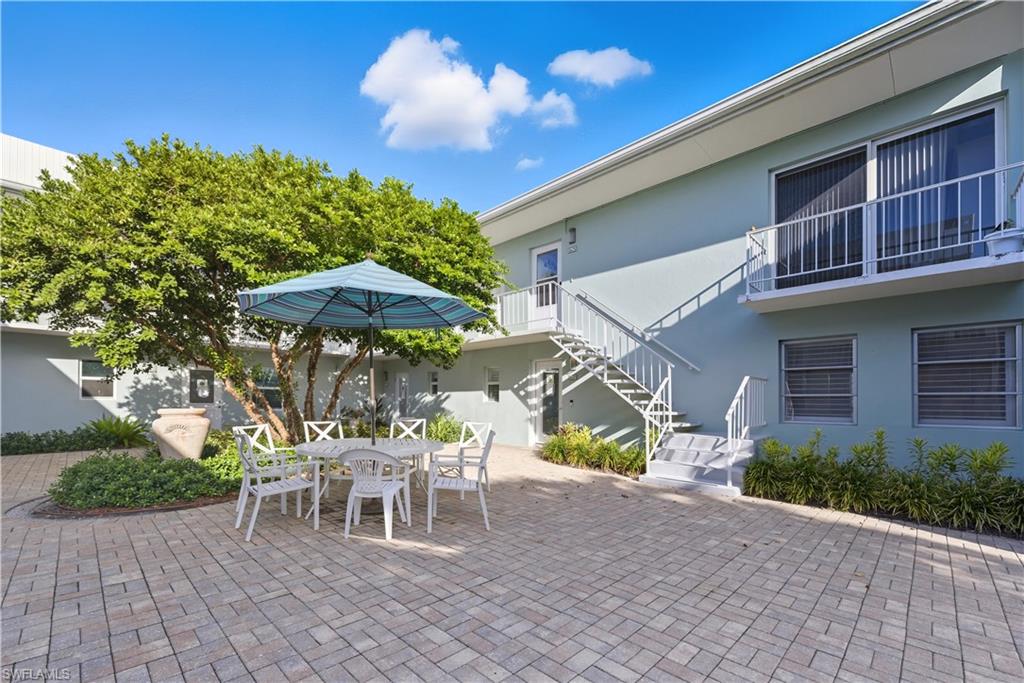 View of patio featuring outdoor dining area and stairs