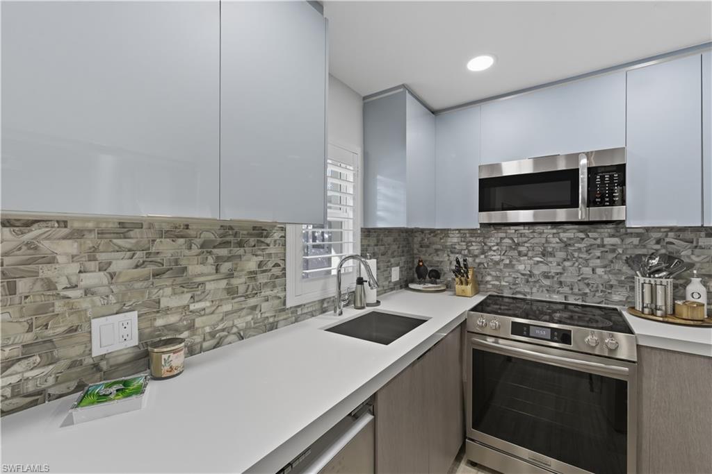 Kitchen with appliances with stainless steel finishes, modern cabinets, backsplash, and recessed lighting
