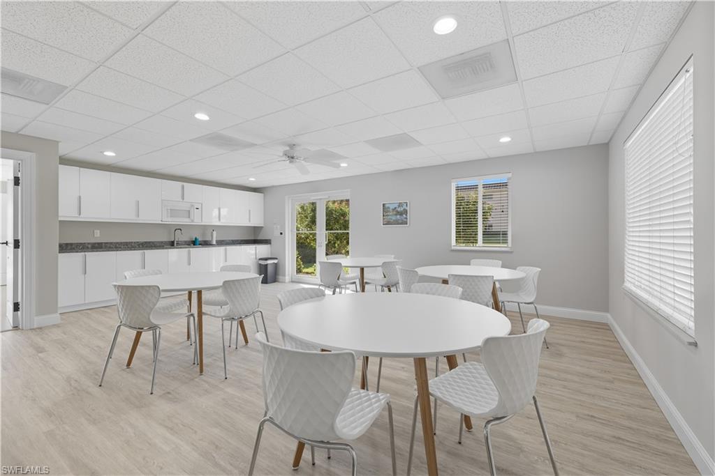 Dining space featuring light wood-type flooring, ceiling fan, a drop ceiling, and recessed lighting