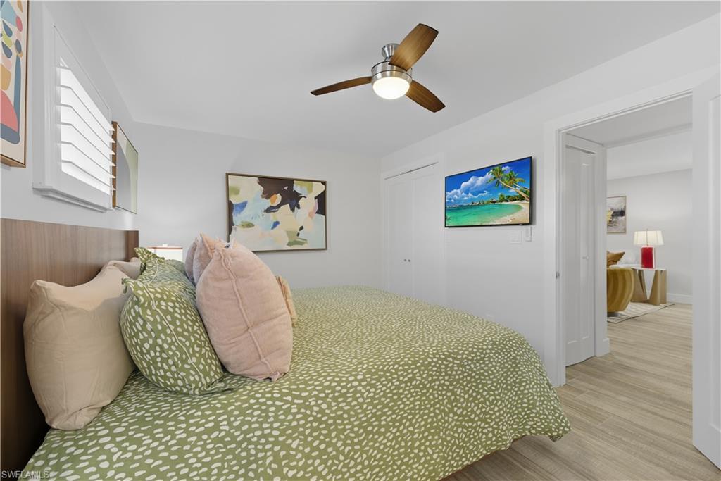 Bedroom with wood finished floors, ceiling fan, and a closet