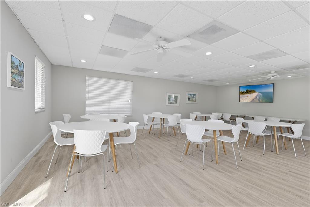 Dining space with ceiling fan, a drop ceiling, light wood-type flooring, and recessed lighting