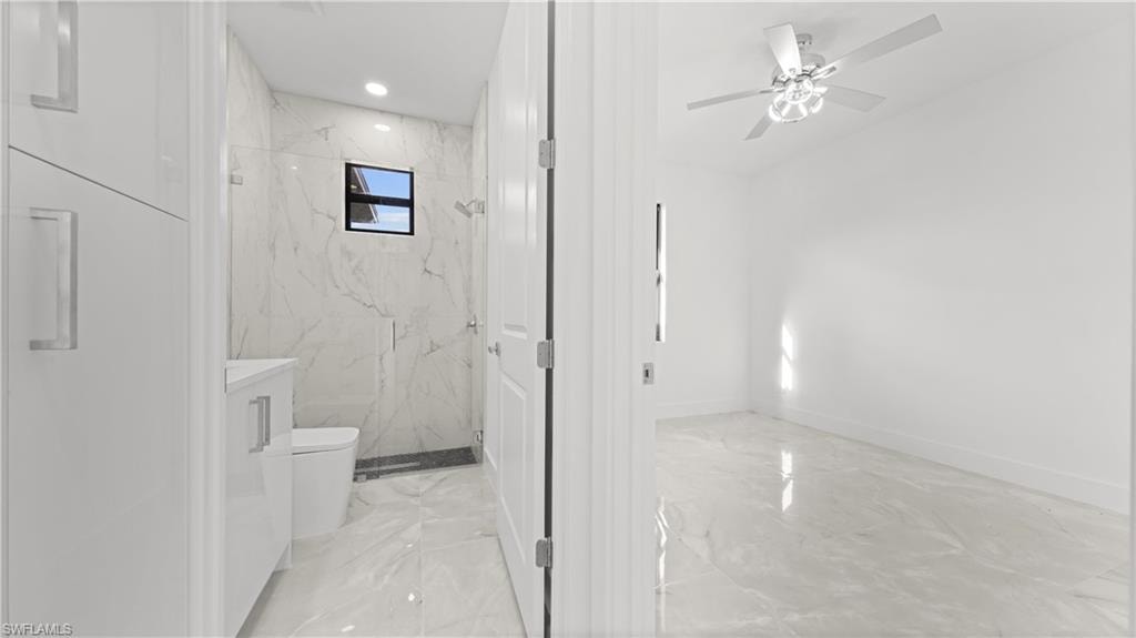 Bathroom featuring light marble finish floors, a marble finish shower, a ceiling fan, vanity, and recessed lighting