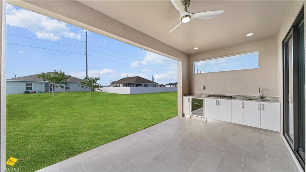 View of patio / terrace with area for grilling, ceiling fan, and beverage cooler