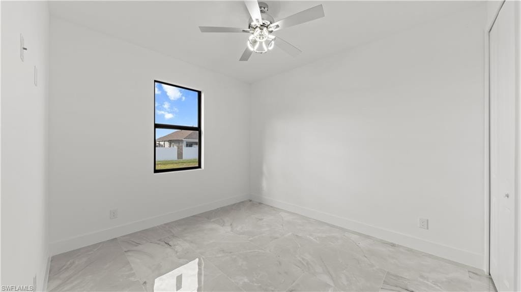 Unfurnished room with baseboards and a ceiling fan