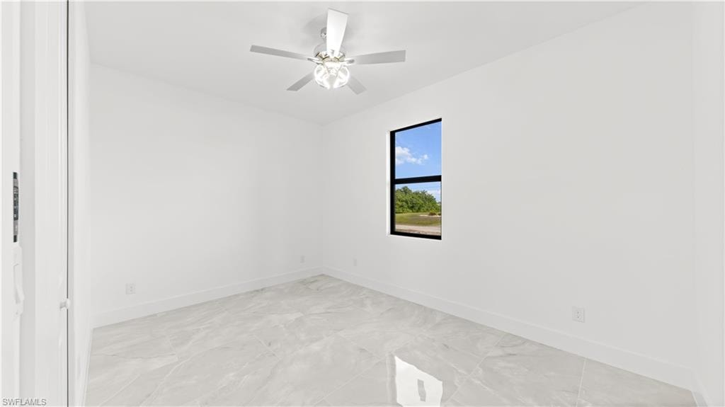 Unfurnished room featuring baseboards and ceiling fan