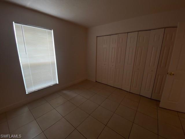 Unfurnished bedroom featuring a closet and light tile patterned floors