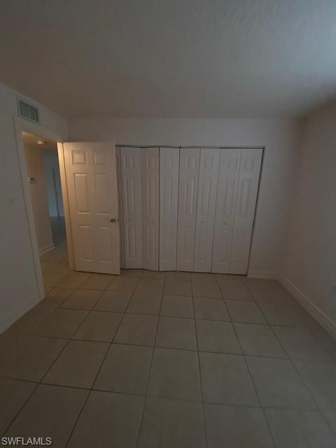 Unfurnished bedroom with a closet and tile patterned flooring