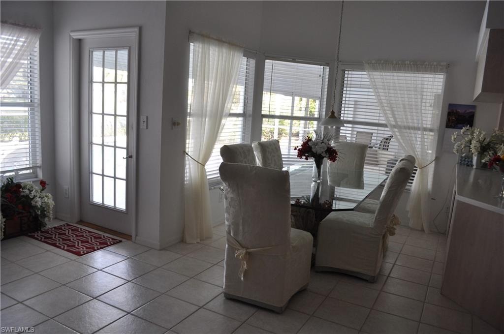 Dining room with light tile patterned floors and plenty of natural light
