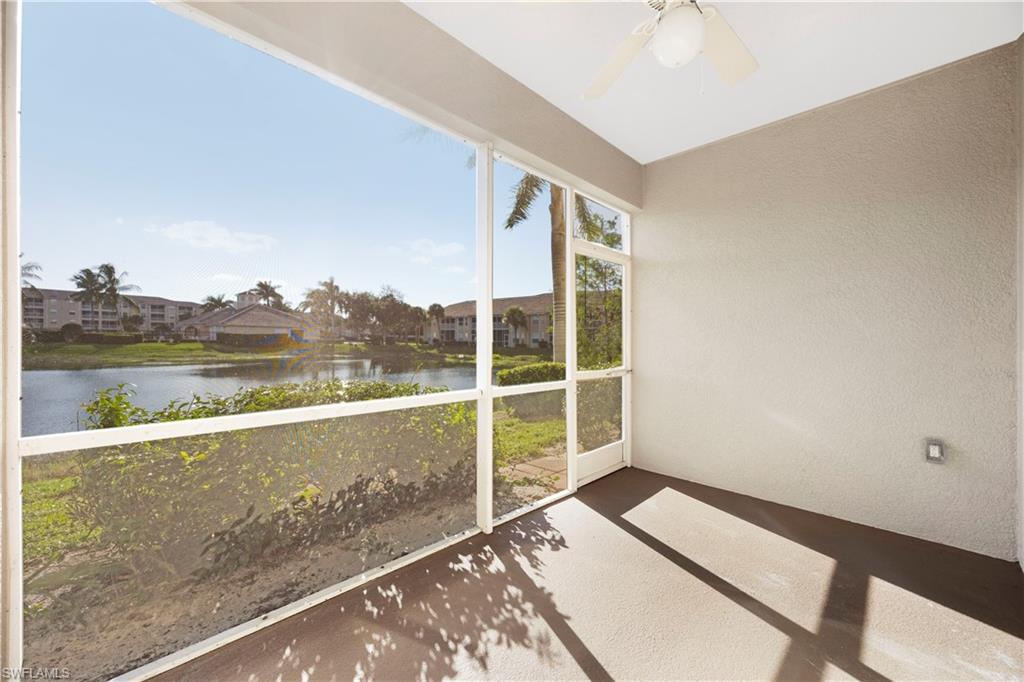 Unfurnished sunroom featuring a water view and a ceiling fan