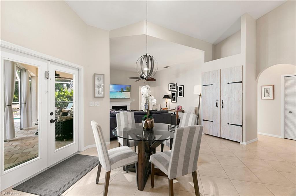 Tiled dining area with high vaulted ceiling and a notable chandelier