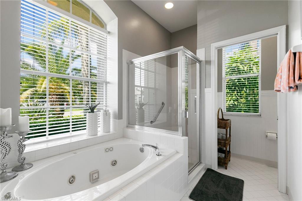 Bathroom with tile patterned flooring, shower with separate bathtub, and a wealth of natural light