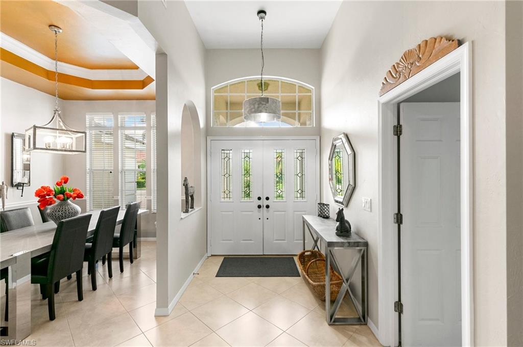 Foyer entrance featuring light tile patterned floors, a chandelier, and ornamental molding