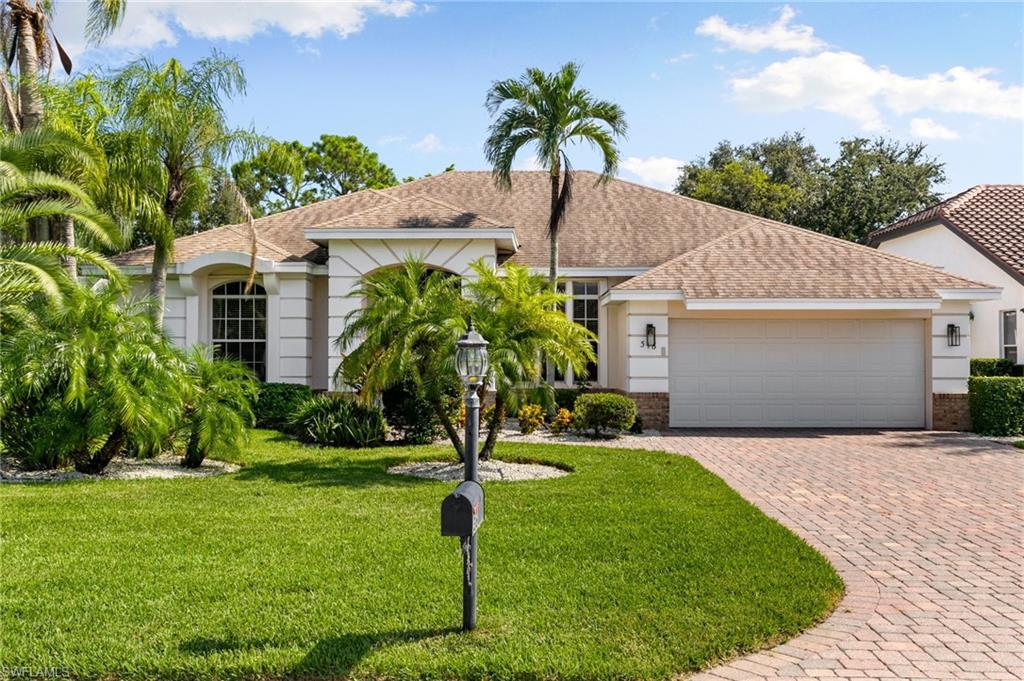 View of front of house with a front yard and a garage