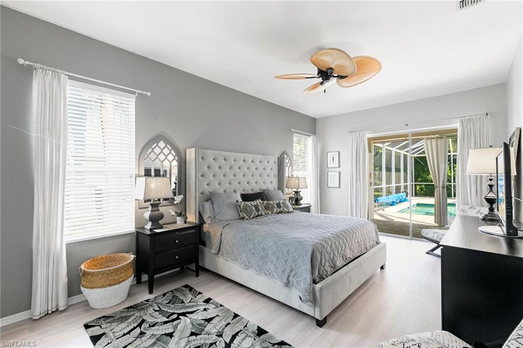 Bedroom featuring ceiling fan, light hardwood / wood-style floors, access to outside, and multiple windows