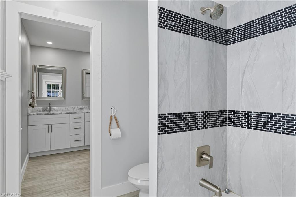 Bathroom featuring vanity, bathtub / shower combination, and light wood finished floors