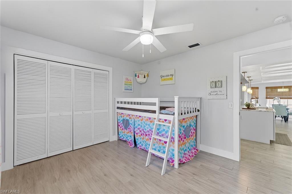 Bedroom featuring light wood-style floors, a closet, and ceiling fan