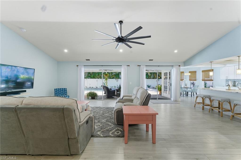 Living area featuring vaulted ceiling, recessed lighting, ceiling fan, and light wood-type flooring